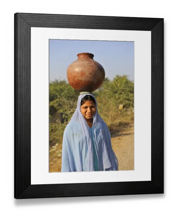 Framed Print : Indian girl carrying water container on head, near Bharatpur, Rajasthan, India, December