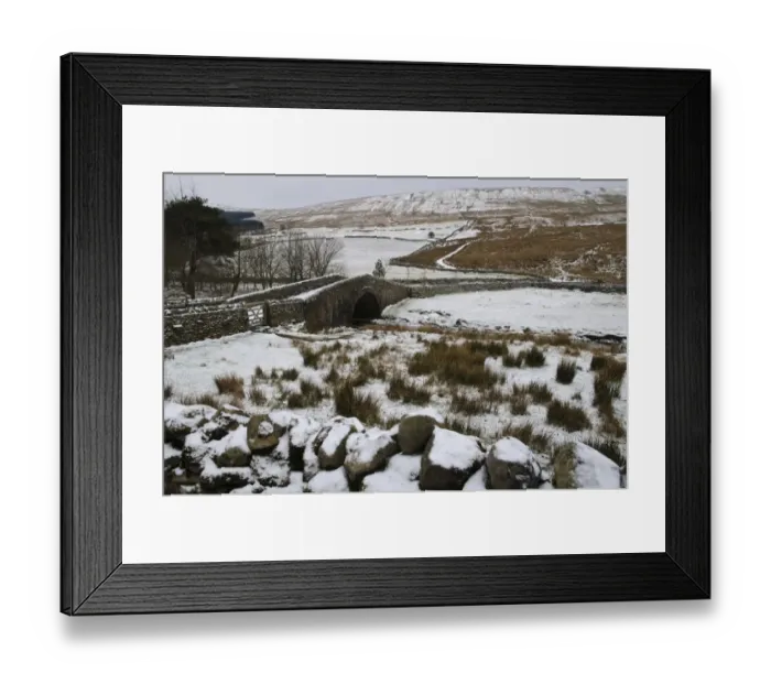 Framed Print : View of stream flowing through snow covered fields and under stone bridge, with ridge of Widdale Fell in background Framed Print : View of stream flowing through snow covered fields and under stone bridge, with ridge of Widdale Fell in background