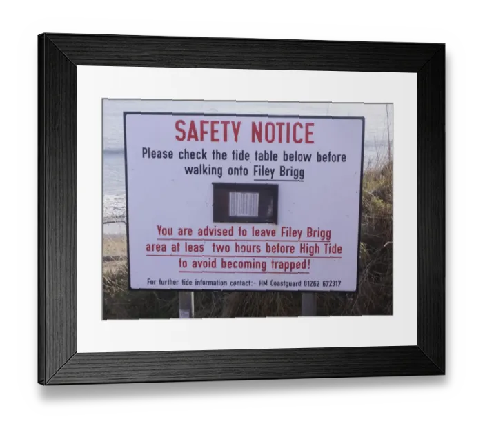 Framed Print : Safety Notice, Please check the tide table below before walking onto Filey Brigg sign on coastal peninsula