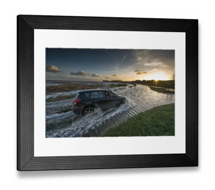 Framed Print : 4x4 driving through flooded coast road beside coastal marshland after tidal surge, Cley Marshes Reserve