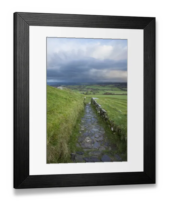 Framed Print : View of path and gate leading from 13th century church on moorland at sunrise