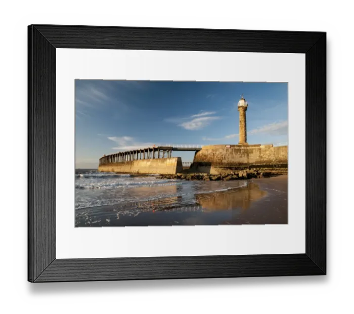 Framed Print : View of beach and pier with 19th century stone lighthouse in evening sunlight, East Pier, Whitby, North Yorkshire Framed Print : View of beach and pier with 19th century stone lighthouse in evening sunlight, East Pier, Whitby, North Yorkshire