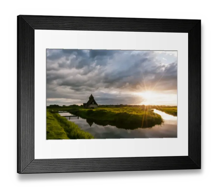Framed Print : View of grazing marsh with footbridge across flooded ditch and church at sunset, St Framed Print : View of grazing marsh with footbridge across flooded ditch and church at sunset, St