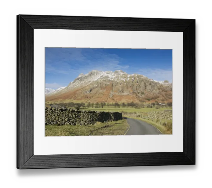 Framed Print : View across road, drystone walls and valley pasture towards snow covered fell, Langdale Fell, Great Langdale