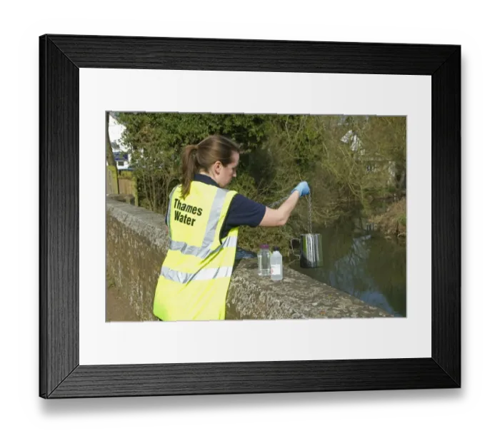 Framed Print : Water quality scientist from Thames Water, taking samples to be tested for traces of metaldehyde, carbetamide and propyzamide, River Cherwell, Cropredy Bridge, Oxfordshire, England, march