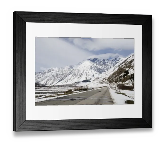 Framed Print : View of road and snow covered mountains, leading to Kazbegi, Great Caucasus, Caucasus Mountains, Georgia, april
