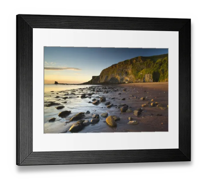 Framed Print : Rocks on sandy beach with sea cliffs at sunrise, Black Nab, Saltwick Bay, North Yorkshire, England, august Framed Print : Rocks on sandy beach with sea cliffs at sunrise, Black Nab, Saltwick Bay, North Yorkshire, England, august