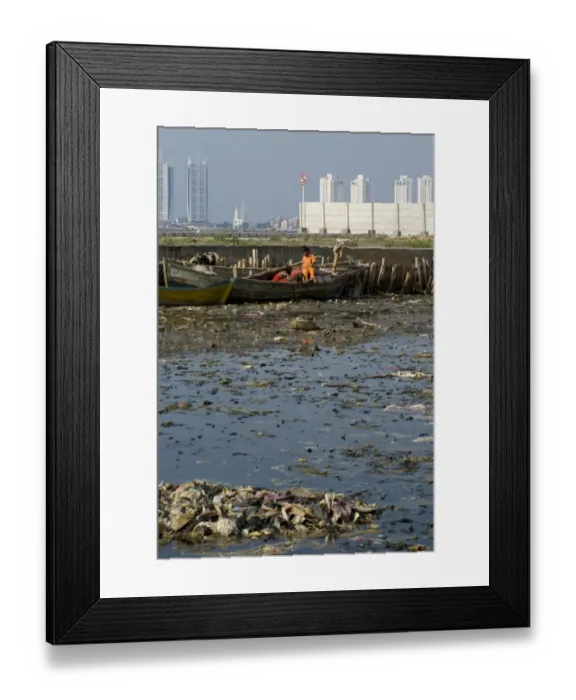 Framed Print : Children on boat in rubbish filled water, with city skyscrapers in background, Muara Karang, Jakarta, Java, Indonesia Framed Print : Children on boat in rubbish filled water, with city skyscrapers in background, Muara Karang, Jakarta, Java, Indonesia
