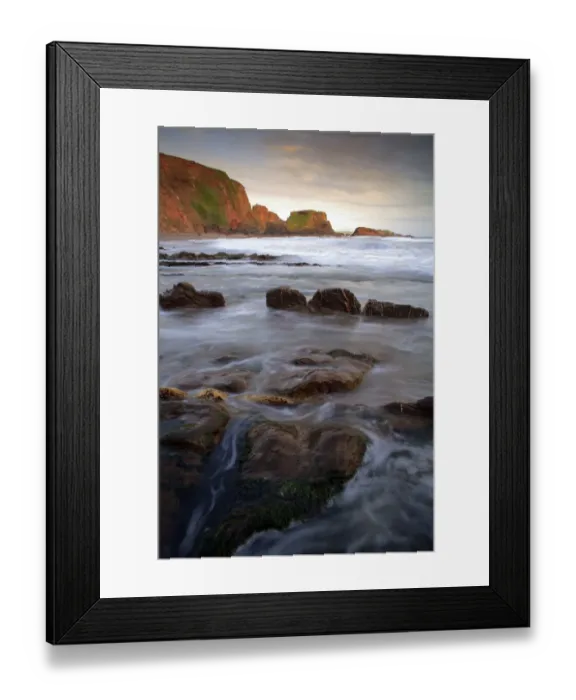 Framed Print : View of rocks on beach in cove at sunset, Westcombe Beach, Devon, England Framed Print : View of rocks on beach in cove at sunset, Westcombe Beach, Devon, England