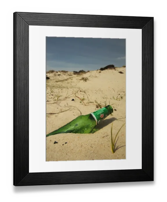 Framed Print : Glass beer bottle discarded on sandy beach, Studland, Dorset, England, may Framed Print : Glass beer bottle discarded on sandy beach, Studland, Dorset, England, may