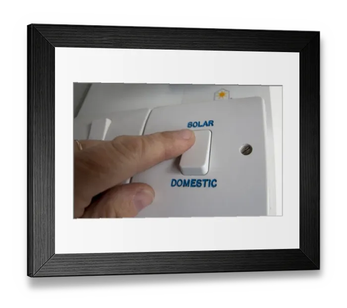 Framed Print : Person turning on solar power switch, England