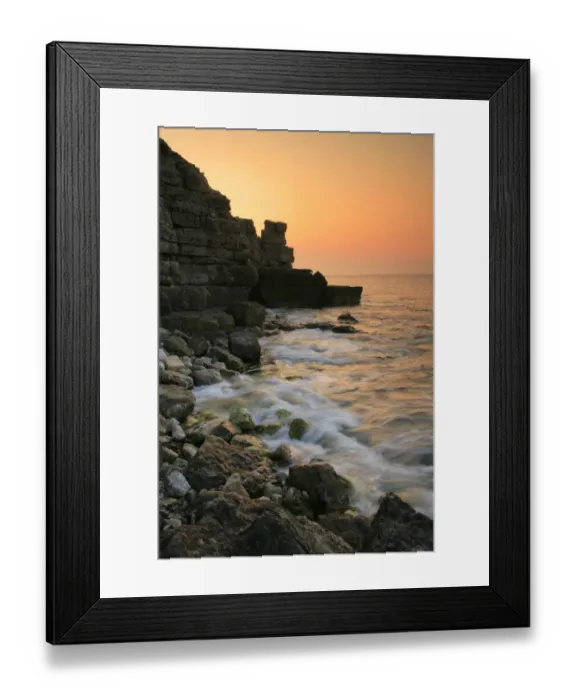 Framed Print : View of waves on rocky beach and old quarry on cliffs at sunset, Winspit Bay, near Worth Matravers, Isle of Purbeck