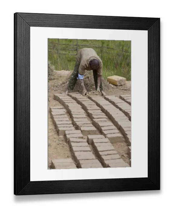 Framed Print : Worker forming loam bricks, Uganda Framed Print : Worker forming loam bricks, Uganda