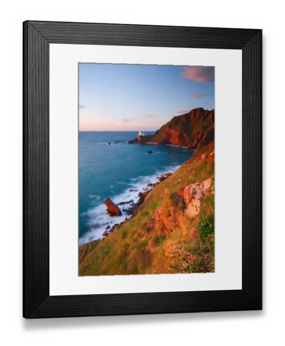 Framed Print : View of sea cliffs with distant lighthouse at sunset, with wreck of MV Johanna in foreground, Hartland Lighthouse Framed Print : View of sea cliffs with distant lighthouse at sunset, with wreck of MV Johanna in foreground, Hartland Lighthouse