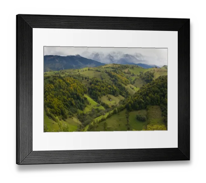 Framed Print : View of mixed woodland and pasture on mountain slopes, distant peaks with first snow of autumn, South of Bran