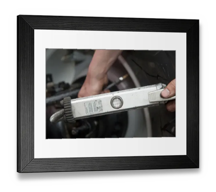 Framed Print : Mechanic checking tyre pressure in tractor tyres, England, october