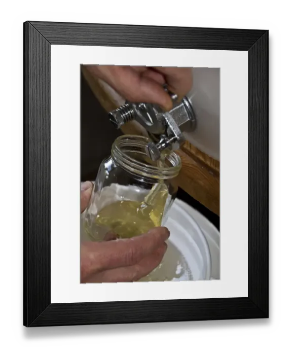 Framed Print : Filling a jar of honey from a storage drum. After the honey has been spun from the comb its filtered into the storage Framed Print : Filling a jar of honey from a storage drum. After the honey has been spun from the comb its filtered into the storage