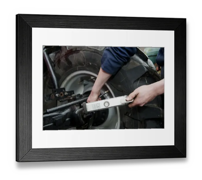 Framed Print : Mechanic checking tyre pressure in tractor tyres, England, october Framed Print : Mechanic checking tyre pressure in tractor tyres, England, october