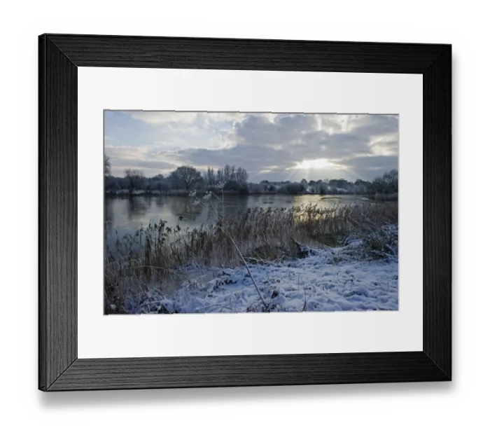 Framed Print : View of snow covered riverbank and frozen river, Ferry Lane Wood, River Yare, The Broads, near Postwick, Norfolk