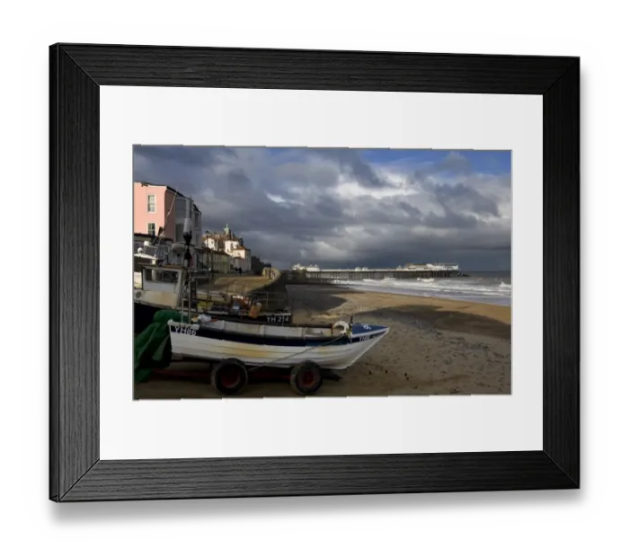 Framed Print : View of fishing boats, beach and pier of seaside town, with stormclouds overhead, Cromer Pier, Cromer, Norfolk Framed Print : View of fishing boats, beach and pier of seaside town, with stormclouds overhead, Cromer Pier, Cromer, Norfolk