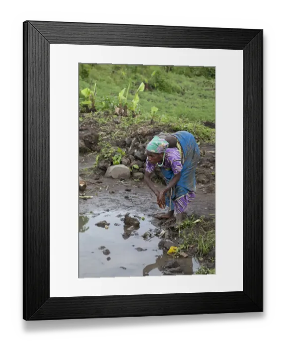 Framed Print : Pygmy woman with child, washing hands at waterhole, Virunga Mountains, Uganda Framed Print : Pygmy woman with child, washing hands at waterhole, Virunga Mountains, Uganda