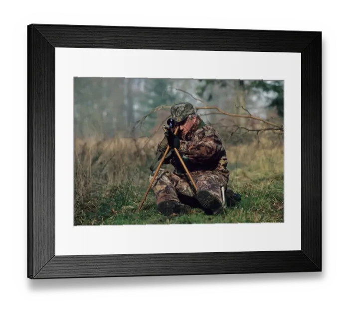 Framed Print : Hunting, deer stalker sitting on low seat and using tripod to support rifle, England Framed Print : Hunting, deer stalker sitting on low seat and using tripod to support rifle, England