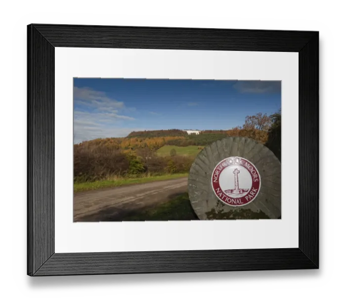 Framed Print : North York Moors National Park sign on millstone, with Kilburn White Horse hill figure on hillside in background Framed Print : North York Moors National Park sign on millstone, with Kilburn White Horse hill figure on hillside in background