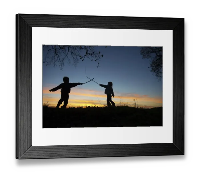 Framed Print : Young children playing, having stick fight at edge of woodland, silhouetted at sunset, Norfolk, England, december Framed Print : Young children playing, having stick fight at edge of woodland, silhouetted at sunset, Norfolk, England, december