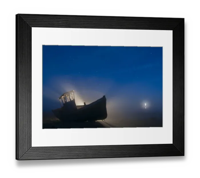 Framed Print : Abandoned fishing boat on shingle beach at night, with distant lighthouse in mist, Dungeness, Kent, England, September Framed Print : Abandoned fishing boat on shingle beach at night, with distant lighthouse in mist, Dungeness, Kent, England, September