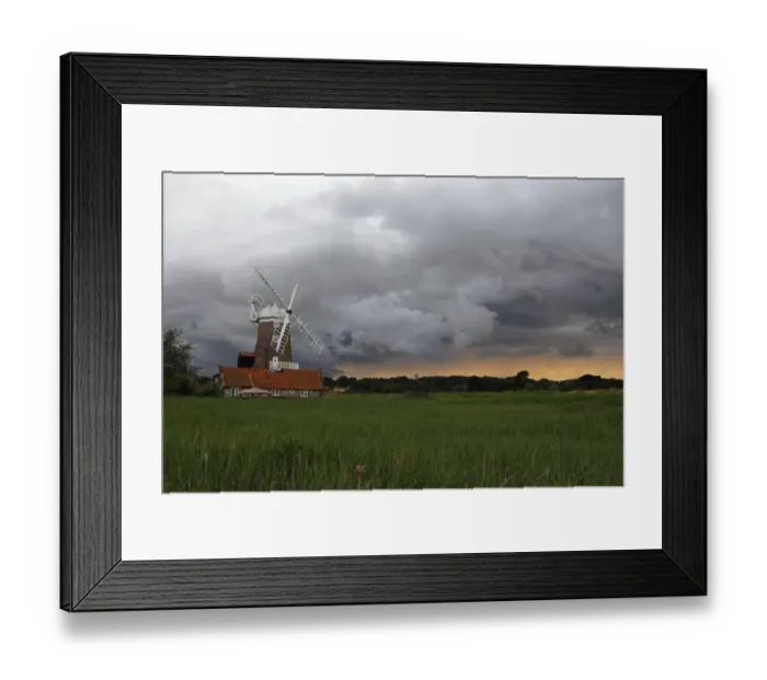 Framed Print : View over coastal reedbed habitat towards windmill and stormclouds, Cley Windmill, Cley Marshes, Cley-next-the-sea