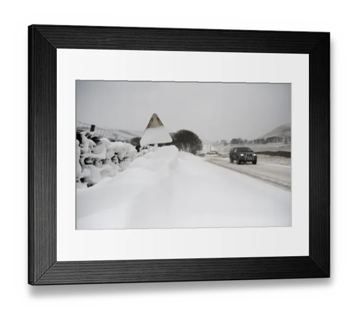 Framed Print : Snow covered roadsign and vehicle travelling along rural road after snowstorm, Cumbria, England, March Framed Print : Snow covered roadsign and vehicle travelling along rural road after snowstorm, Cumbria, England, March