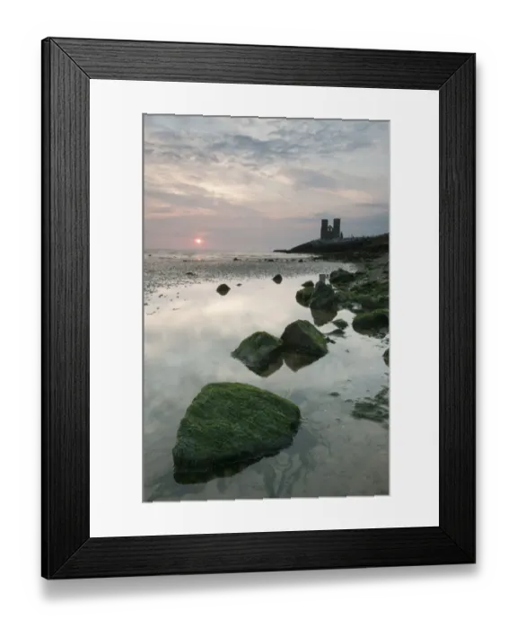 Framed Print : View of seaweed covered rocks beach at low tide, with 12th Century ruined church in distance at sunrise, St