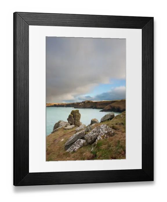 Framed Print : View of coastline with cliffs in evening sunlight and rainclouds gathering overhead