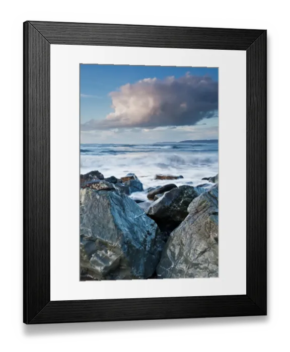 Framed Print : Large boulders of sea defences at bottom of pebble ridge with waves from incoming tide Framed Print : Large boulders of sea defences at bottom of pebble ridge with waves from incoming tide