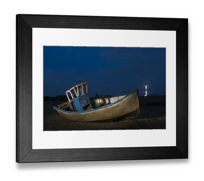 Framed Print : Abandoned fishing boat on shingle beach with distant lighthouse at night, Dungeness, Kent, England, April Framed Print : Abandoned fishing boat on shingle beach with distant lighthouse at night, Dungeness, Kent, England, April