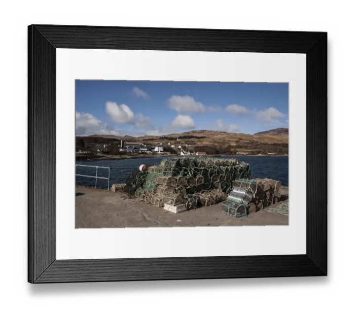 Framed Print : Lobster pots on Jura Pier with Jura Hotel and whiskey distillery behind Framed Print : Lobster pots on Jura Pier with Jura Hotel and whiskey distillery behind