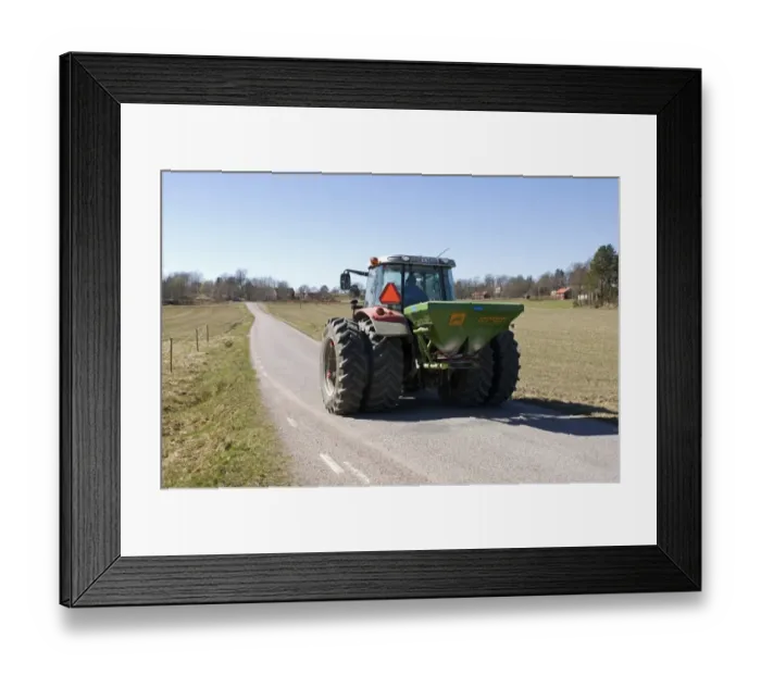 Framed Print : Tractor with Amazone ZA-F fertiliser spreader, driving along rural road, Sweden, spring Framed Print : Tractor with Amazone ZA-F fertiliser spreader, driving along rural road, Sweden, spring