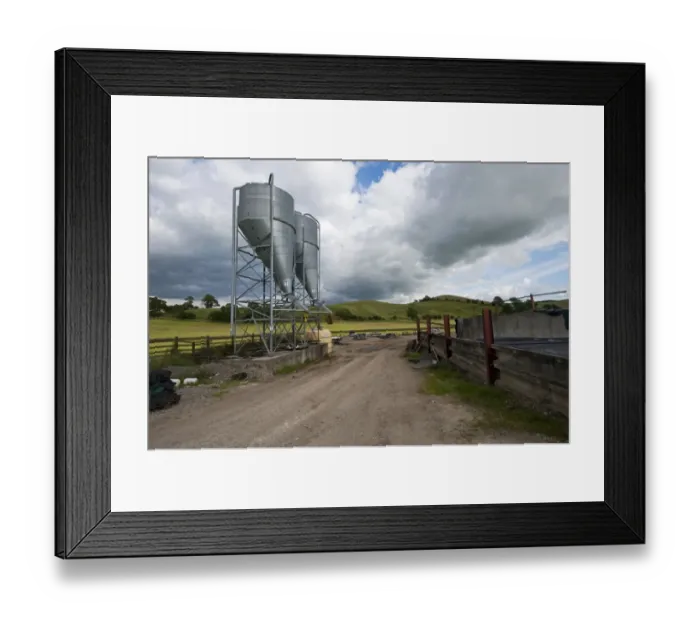 Framed Print : Farmyard with two bulk feed hoppers for animal feed, Yorkshire, England, August