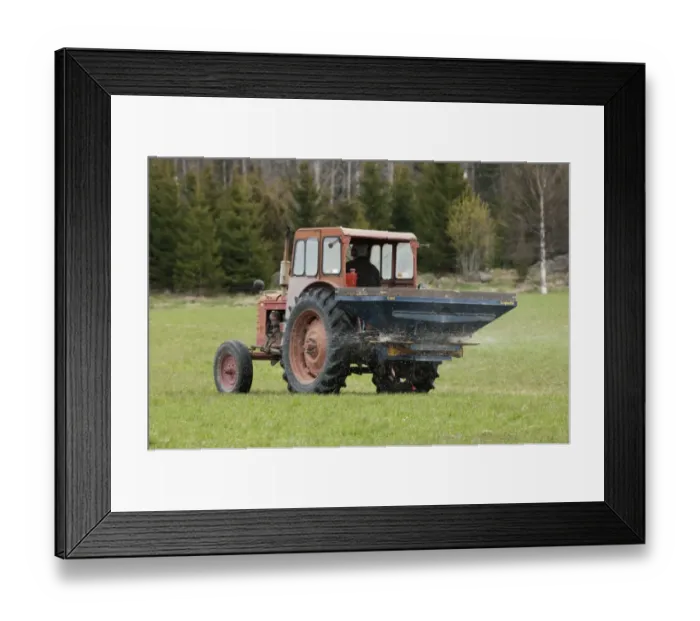 Framed Print : Tractor with fertilizer spreader, spreading nitrogen granular fertilizer on field, Sweden, may