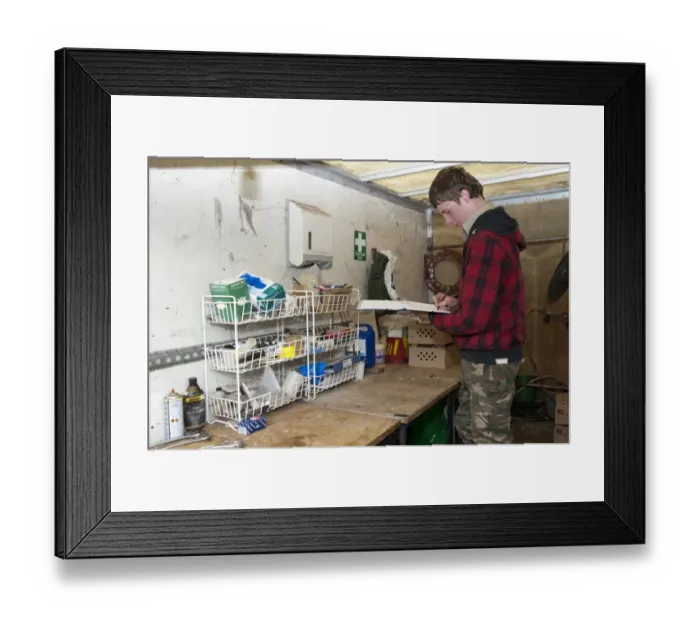Framed Print : Gamebird farming, trainee gamekeeper filling in animal medicine book on shooting estate, England, May Framed Print : Gamebird farming, trainee gamekeeper filling in animal medicine book on shooting estate, England, May