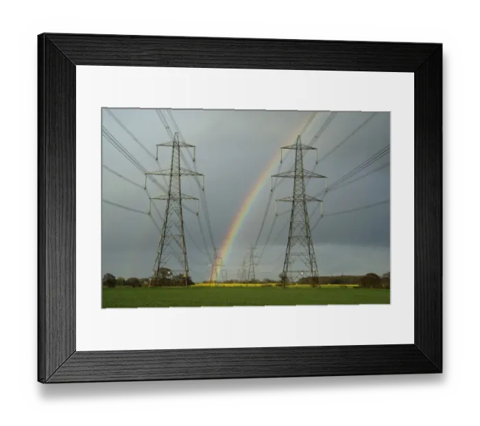 Framed Print : Electricity transmission pylons and rainbow, with flowering oilseed rape field in distance, near Aldeburgh, Suffolk Framed Print : Electricity transmission pylons and rainbow, with flowering oilseed rape field in distance, near Aldeburgh, Suffolk
