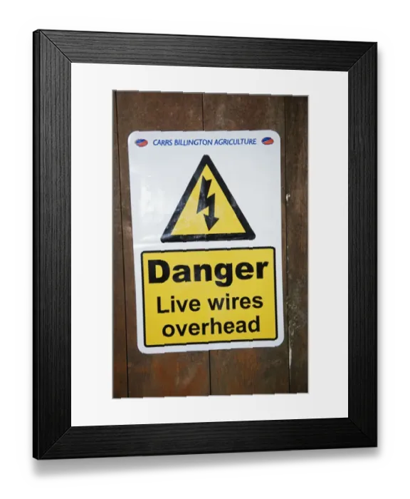 Framed Print : Danger, Live wires overhead sign warning of low power cables on door of farm feed store, England, April Framed Print : Danger, Live wires overhead sign warning of low power cables on door of farm feed store, England, April