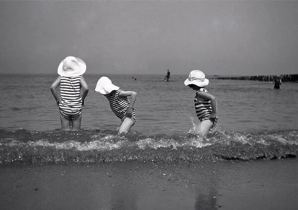 Three children paddling in the sea