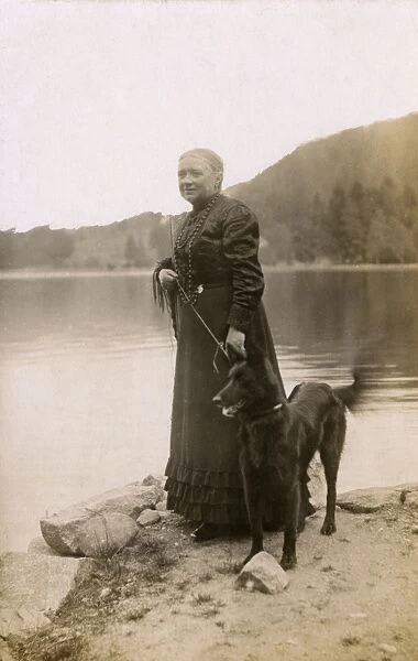 Woman with a dog by a lake, Vosges, France