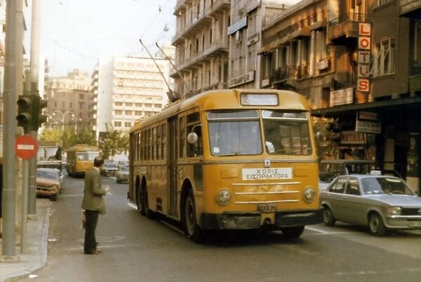 Yellow cable buses on a busy main road in Athens