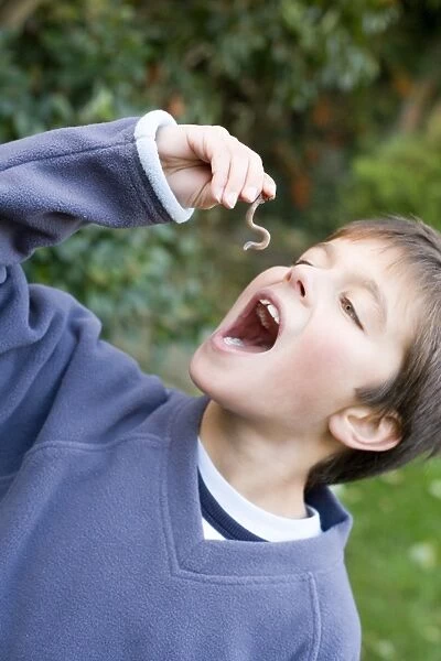 Boy pretending to eat an earthworm