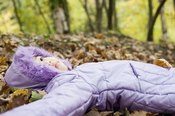 Girl lying on autumn leaves