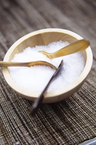 Salt in a wooden bowl. Serving spoons are in the bowl