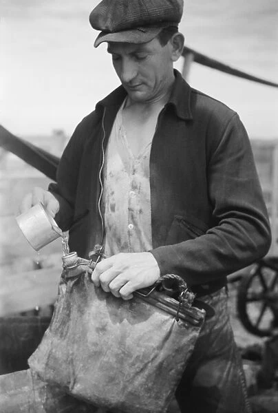 Sheepherder filling water bag, 1939