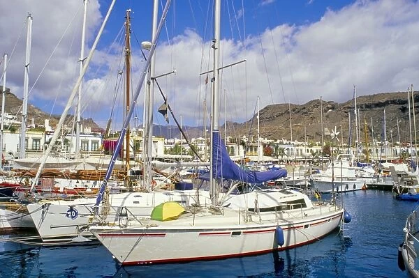 Boats in Puerto Mogan harbour and promenade in background, Puerto de Mogan